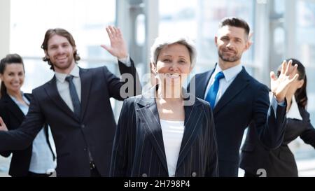 Team der Gewinner des Unternehmens. Gruppe von glücklichen Menschen in formeller Kleidung, die feiern, gestikulieren, die Arme hochhalten und Positivität ausdrücken Stockfoto