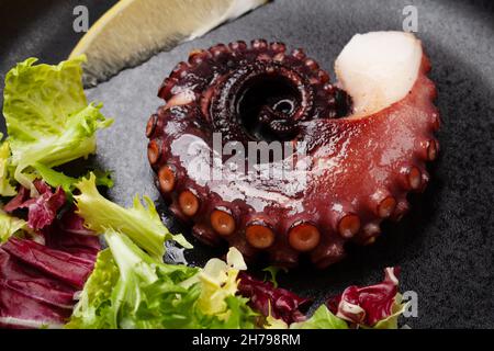 Gegrillter Oktopus mit Kräutern und Gewürzen auf einer Pfanne Stockfoto