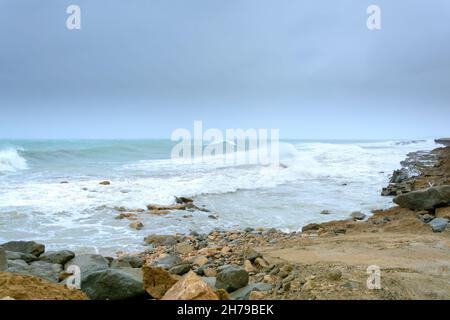 Wütende türkisgrüne Farbe massive RIP curl einer Wellen, wie es Barrel rollt entlang des Strandes. Wilde Wellen Pfund die Küste von chabahar in stürmischen Tag w Stockfoto