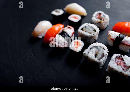 japanisches Sushi-Essen. Maki und Brötchen mit Thunfisch, Lachs, Garnelen, Krabben und Avocado. Draufsicht auf verschiedene Sushi-Sorten. Stockfoto