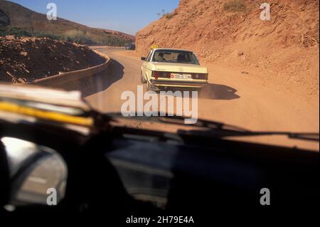 Reisen zwischen Imlil und Marrakesch auf einer mit Sand und Felsen bedeckten Straße nach einem Erdrutsch im Hohen Atlas in Marokko. Stockfoto