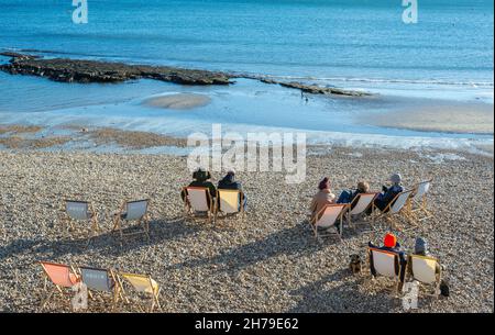 Lyme Regis, Dorset, Großbritannien. 21st. November 2021. Wetter in Großbritannien: Besucher und Einheimische wärmen sich an einem sonnigen und hellen, aber kühlen Nachmittag auf einen Spaziergang entlang der Strandpromenade des malerischen Badeortes Lyme Regis. Der Kredit: Celia McMahon/Alamy Live Nachrichten Stockfoto