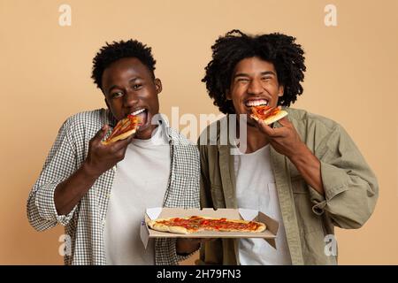 Leckerer Snack. Zwei Hugry Black Jungs Essen Italienische Pizza Aus Box Stockfoto