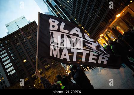 Chicago, Usa. 20th. November 2021. Ein Protestler hält während der Demonstration eine Flagge der schwarzen Menschenleben. Über tausend Demonstranten versammelten sich auf dem Federal Plaza in Chicago, um gegen den Freispruch von Kyle Rittenhouse zu protestieren. Die Demonstranten marschierten weiter durch die Straßen von Chicago, zusammen mit Reverend Jesse Jackson SR und Frank Chapman. (Foto: Karla Cote/SOPA Images/Sipa USA) Quelle: SIPA USA/Alamy Live News Stockfoto