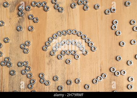 WiFi-Schild aus Metallmuttern auf einem Holztisch. Draufsicht. Stockfoto