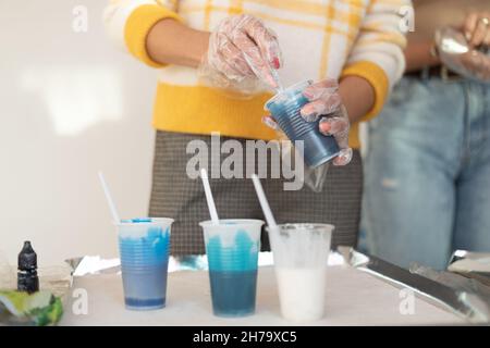 Epoxidharz verschiedene blaue Farbe in Tasse zum Gießen stabilisierendes Holz, abstrakte Kunst. Prozess der Herstellung von Zubehör aus Harz.Mischen bunt von Harz Stockfoto