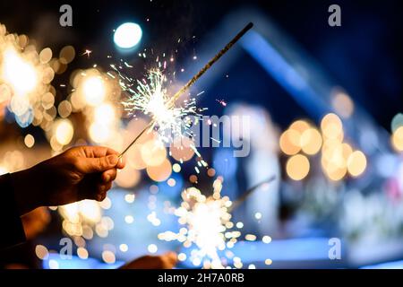 Mann Hand hält einen brennenden Funkler. Feuer in Bengalen Stockfoto