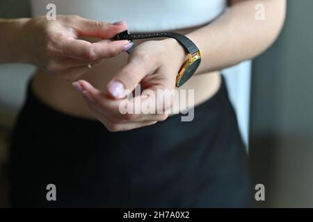 Goldene Armbanduhr für Frauen an der Hand des Mädchens Stockfoto