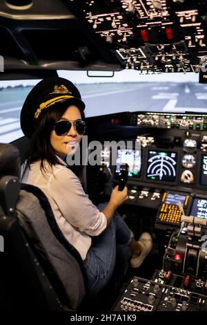 Pilotin der Kapitän des Flugzeugs bereitet sich auf den Start im Cockpit des Flugzeugs vor. Stockfoto