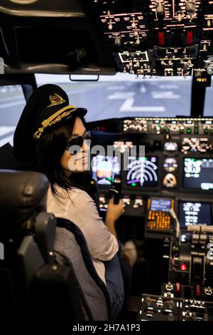 Pilotin der Kapitän des Flugzeugs bereitet sich auf den Start im Cockpit des Flugzeugs vor. Stockfoto