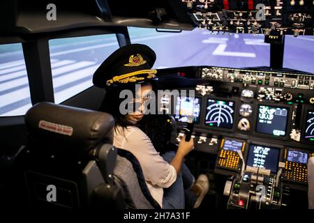 Pilotin der Kapitän des Flugzeugs bereitet sich auf den Start im Cockpit des Flugzeugs vor. Stockfoto