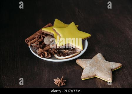 WeihnachtsLebkuchen in Form von Sternen, Gewürzen und Honig auf einem Holztisch. Stockfoto