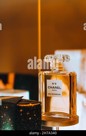 Präsentation der Glasflasche Chanel No. 5 Parfüm der französischen Luxusmarke Chanel vor dem goldenen Hintergrund. Berühmter weiblicher Duft. Stockfoto