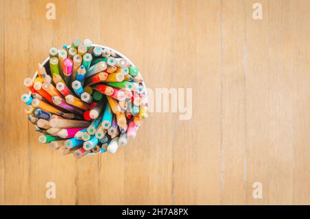 Alte Stifte auf einem Holzbrett eingefärbt. Schulmaterial mit Platz für Text. Stockfoto