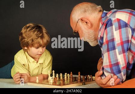 Familienbeziehung. Großvater und Enkel spielen Schach. Brettspiel. Opa unterrichtet Enkel beim Schachspielen. Stockfoto