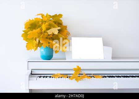 Ahornblätter auf dem Klavier in einer blauen Vase. Das Konzept des Herbstes. Vorderansicht. Isoliert. Russland. Tschechow. Stockfoto