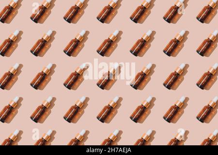 Muster aus Glas Tropfflaschen mit ätherischem Öl, Hyaluronsäure oder Serum auf pastellbeigem Hintergrund. Mockup-Bild. Moderne Bio-Kosmetik Stockfoto