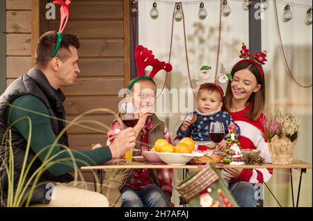 Eine glückliche Familie sitzt am Tisch und feiert weihnachten Stockfoto