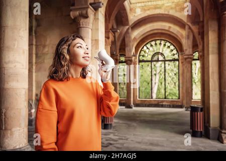 Glückliche asiatische Frau trinkt gesundes Mineralwasser in einem der berühmten europäischen medizinischen und therapeutischen Resorts Stockfoto