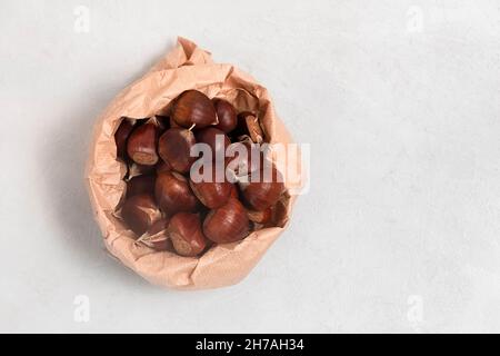 Draufsicht auf frische Kastanien auf neutralgrauem Hintergrund mit Kopierraum Stockfoto