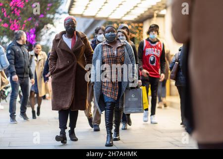 London, Großbritannien. 21st. November 2021. In London sahen die Menschen Gesichtsmasken und Einkaufstaschen tragen. Kredit: SOPA Images Limited/Alamy Live Nachrichten Stockfoto