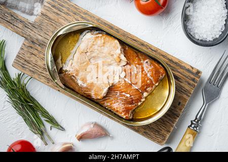 Wild Alaska Lachs Räucherfischset in Dosen, auf Holzschneidebrett, auf weißem Hintergrund mit Kräutern und Zutaten, Draufsicht flach Stockfoto