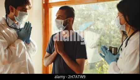 Ein glücklicher Klient, der den Ärzten in einem Krankenhaus seine Dankbarkeit zeigt Stockfoto