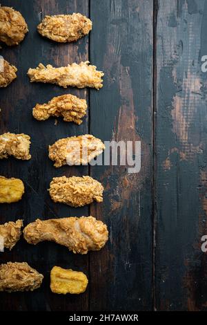 Hausgemachte knusprig gebratene Hühnerteile auf alten dunklen Holztisch, Draufsicht, mit Kopieplatz. Stockfoto