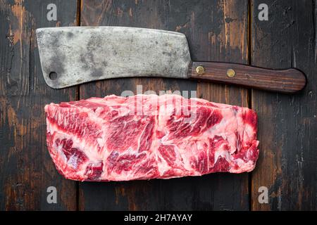 RAW Rib Eye Beef Steak marmoriertes Fleisch Ganzschnitt-Set, mit altem Fleischermesser, auf altem dunklen Holztisch Hintergrund, Draufsicht flach liegend Stockfoto