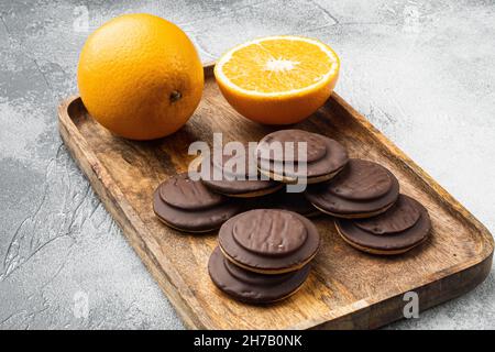 Jaffa-Kuchen. Plätzchen mit dunkler Schokolade bedeckt und mit orangefarbenem Marmeladenset gefüllt, auf grauem Hintergrund Stockfoto