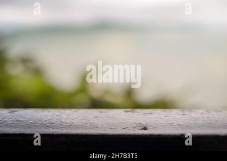 Unscharfer Hintergrund Baum und Meer. Metallgeländer. Unschärfe Stockfoto