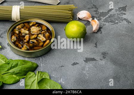 Pasta mit Muscheln, Rohzutaten, auf grauem Steintisch-Hintergrund, mit Platz für Text Stockfoto