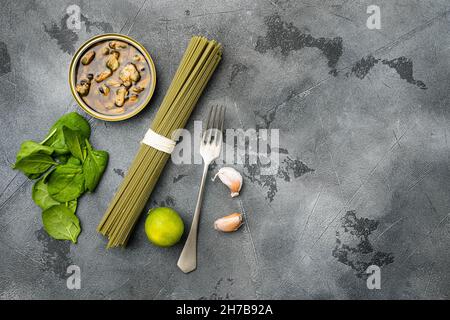 Rohzutaten hausgemachte Pasta Spaghetti mit Muscheln Set, auf grauem Steintisch Hintergrund, Draufsicht flach liegend, mit Platz für Text Stockfoto