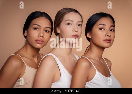 Kaukasische, afroamerikanische und asiatische junge Frauen posieren gemeinsam für die Kamera Stockfoto