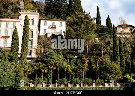 Alte Villen umgeben von Bäumen hinter einem Zaun. Comer See, Italien Stockfoto