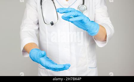 Arzt, der Platz für das Produkt oder den Text vorstellt und zeigt. Arzt leert die Handfläche in einem medizinischen Handschuh. Stockfoto