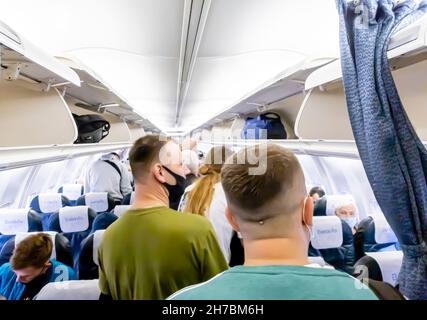 Passagiere mit Gesichtsmasken, die ein Flugzeug der Belavia Boeing 737-800 verlassen Stockfoto