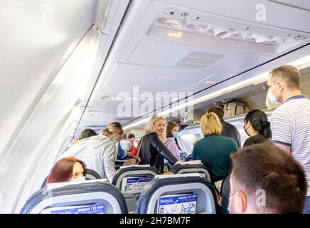 Passagiere mit Gesichtsmasken, die ein Flugzeug der Belavia Boeing 737-800 verlassen Stockfoto