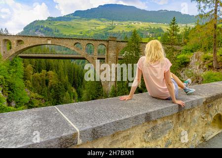 Frau an der Solis Viaduktbrücke der Schweizer Eisenbahn in der Schweiz. Schweizer Zug Bernina und Welterbe in den Bergen des Kantons Graubünden. Albula Railway By Stockfoto