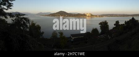 Blick über den Lago Maggiore von Arona auf die Burg Rocca di Angera Stockfoto