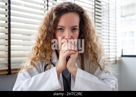 Kaukasische Ärztin hört aufmerksam zu und konzentriert etwas vor sich Stockfoto