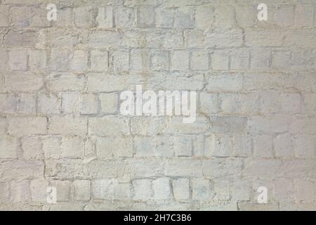 Weiße und unebene weiß getünchte Wand, Textur, Hintergrund. Alte Gebäudewand, bemalt mit Wittling. Wellige, holprige, struppige Oberfläche Stockfoto