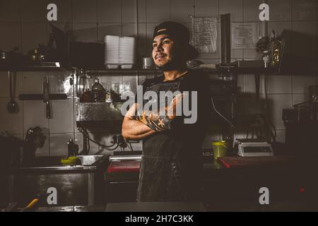 Im Küchenrestaurant steht ein professioneller Koch Stockfoto