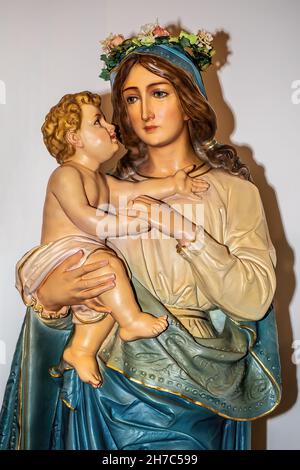 Statue von Maria und dem Jesuskind, das Maria im Monat Maria feiert, mit einer Blumenkrone auf ihrem Kopf in der katholischen Kirche St. Joseph. Stockfoto