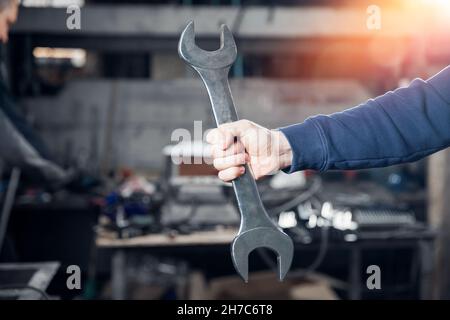 Schraubenschlüssel in den Händen von professionellen Wender Mann Metall arbeiten in der Fabrik. Stockfoto