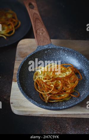 Kartoffeln in einer kleinen Bratpfanne hacken. Kartoffelpfannkuchen. Leckere Gemüsefritter. Kartoffelpasteten oder Kartoffelrösti. Knusprige Kartoffelpüree mit Kartoffelpüree Stockfoto