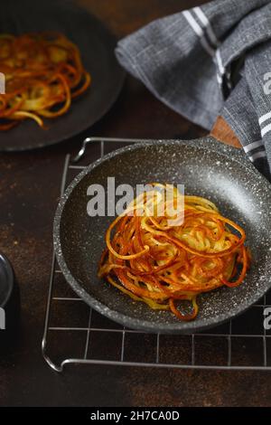 Kartoffeln in einer kleinen Bratpfanne hacken. Kartoffelpfannkuchen. Leckere Gemüsefritter. Kartoffelpasteten oder Kartoffelrösti. Knusprige Kartoffelpüree mit Kartoffelpüree Stockfoto