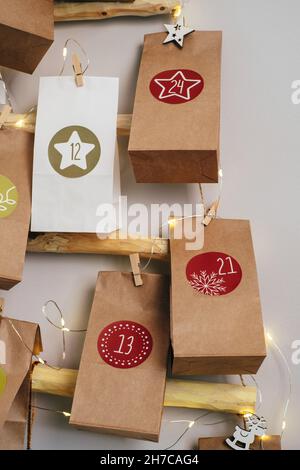 Hängender Weihnachtsadventkalender an der Wand. Handgefertigte Basteltaschen mit Geschenken und Aufgaben für Kinder. Countdown für Heiligabend, warten auf Wunder Stockfoto