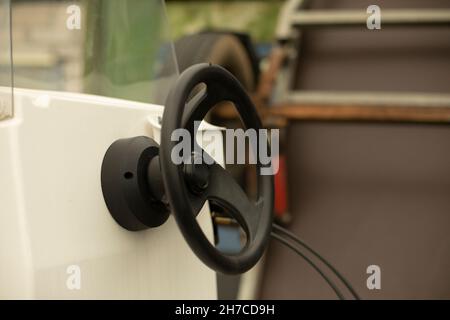 Das Lenkrad des Bootes. Schwarzes Ruder auf dem Boot. Lenkrad des Wassertransports. Details zur Yacht. Stockfoto