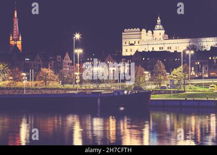 Ufer des Flusses Odra mit herzoglicher Burg in Szczecin bei Nacht, Farbtonung aufgetragen, Polen. Stockfoto